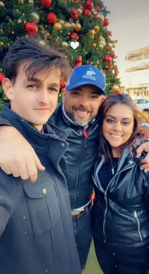 Three friends smiling closely for a photo outdoors.