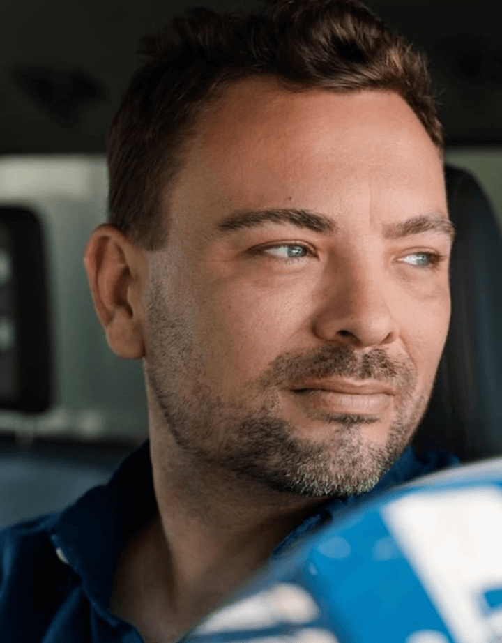 A man with short hair and a beard looking to the side.
